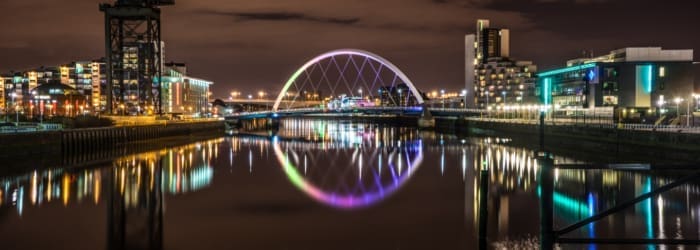Night time imgae of Glasgow river with the wheel in neon colours