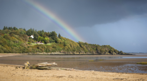Southerness beach in Dumfries and Galloway on a sunny day with a rainbow